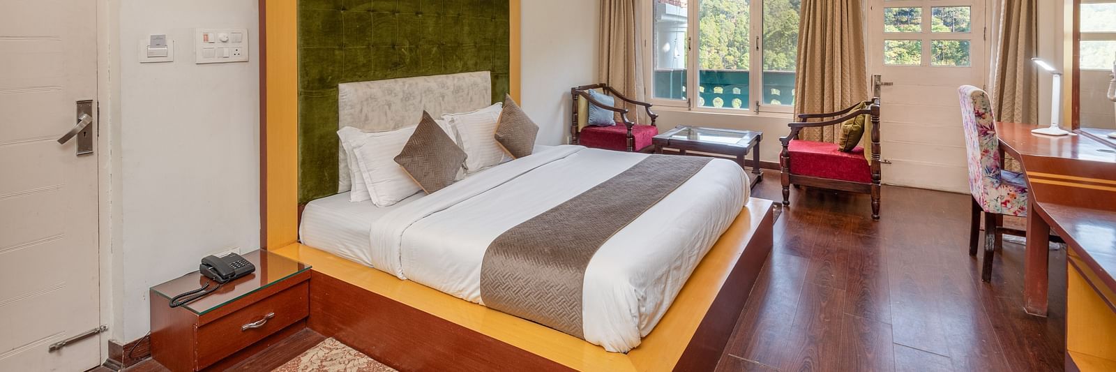 Comfortable and inviting room at DLS Tehri Club Resort with a warm colour scheme and hardwood floors.